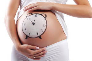 у беременной на животе нарисованы часы