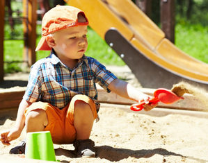ребенок играет в песочнице