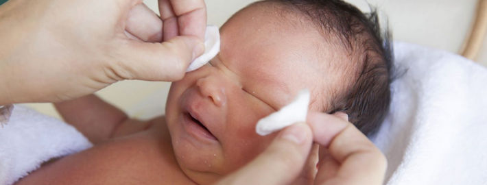 Новорожденному протирают глазки ваткой