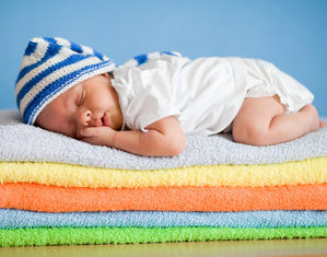 младенец в полосатом колпаке спит