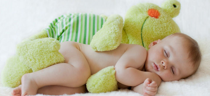 Ребенок спит рядом с игрушкой