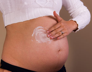 беременная мажет живот кремом