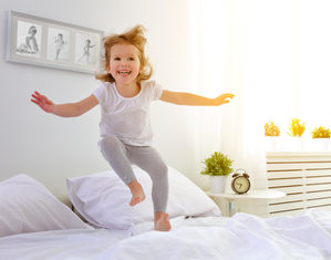 девочка прыгает на кровати