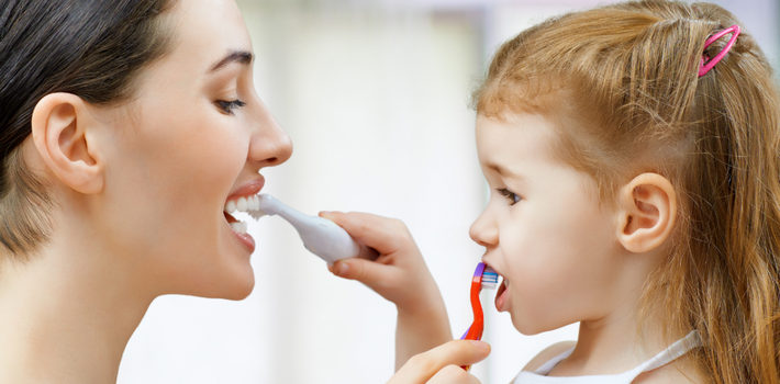 мама с дочерью чистят зубы