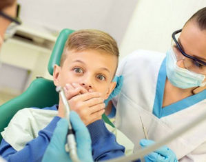 Мальчик закрывает рот у стоматолога