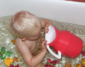 ребенок играет в ванне с водой