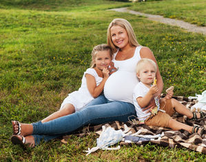 Беременная мама сидит с детьми