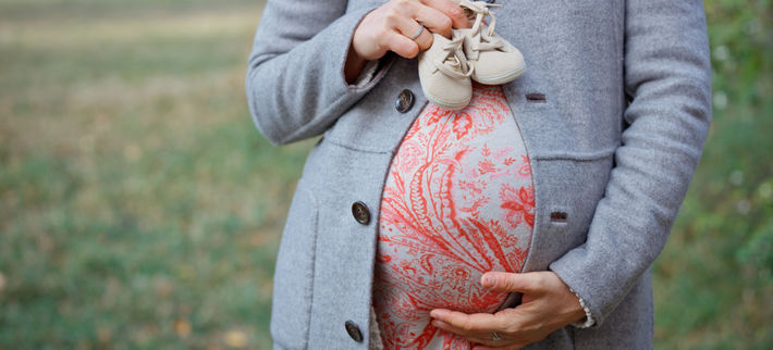 беременная держит пинетки
