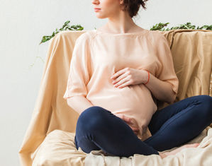 Беременная сидит на диване