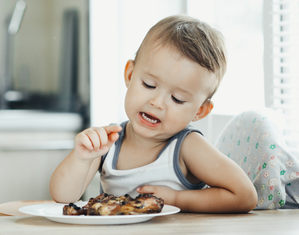 Мальчик перед тарелкой с мясом
