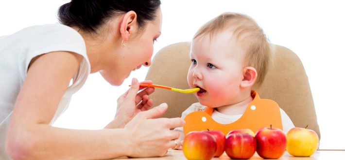 Мама кормит ребенка с ложечки