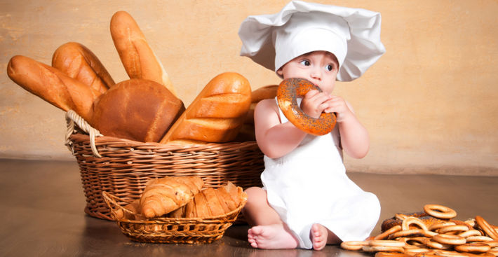ребенок с хлебом ест бублик
