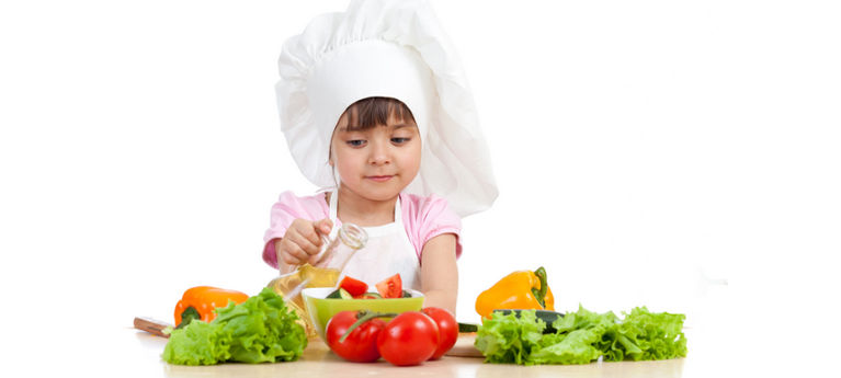 ребенок делает салат из овощей