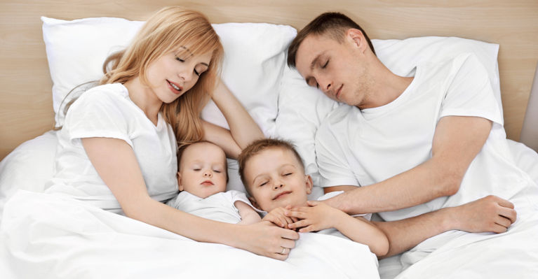 родители спят с детьми и улыбаются