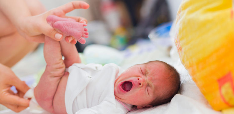 новорожденный зевает во время смены подгузника