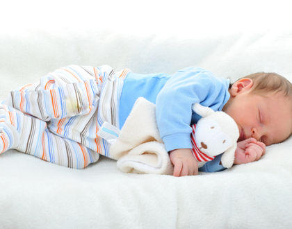 ребенок спит на боку с игрушкой