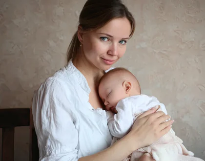 ребенок спит на руках у мамы
