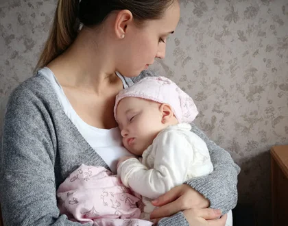 мама держит ребенка на руках